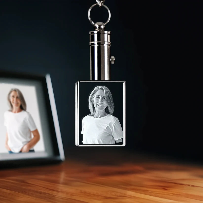 Rectangular crystal photo keychain with laser-engraved portrait, displayed on a wooden surface.